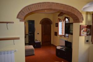 a living room with an archway and a room with a door at Casa Furielli in Radda in Chianti