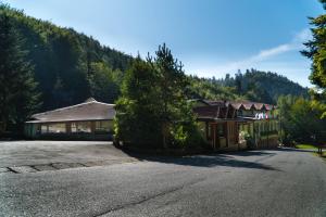 an empty road in front of a building with trees at Hotel Šomka in Drienica