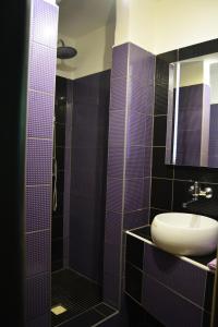 a bathroom with purple tiles and a sink and a shower at Restaurace a penzion Lutena in Dolní Lutyně