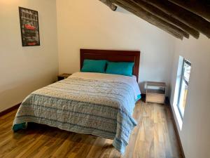 1 dormitorio con 1 cama y suelo de madera en Bellísimo chalet en Zona Colonial (301), en Zipaquirá