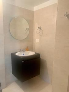 y baño con lavabo y espejo. en Bellísimo chalet en Zona Colonial (301), en Zipaquirá