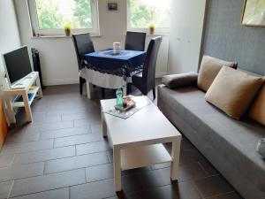 - un salon avec un canapé et une table dans l'établissement Ferienwohnung Nesthäkchen, à Hanerau-Hademarschen