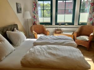 オストゼーバート・カールスハーゲンにあるAppartement Muschelkojeのベッドルーム1室(ベッド1台、椅子2脚、テーブル付)