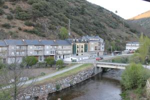 a bridge over a river in a town with buildings at Hostal Burbia in Villafranca del Bierzo
