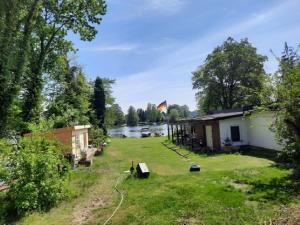 a house with a kite flying over a river at Ferienwohnungen am Krossinsee in Berlin