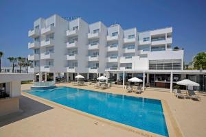 a hotel with a swimming pool in front of a building at Okeanos Beach Boutique Hotel in Ayia Napa