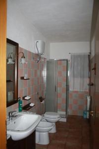 a bathroom with a sink and a toilet and a shower at Villa Elisa Chia Su Giudeu in Domus de Maria +38 photos