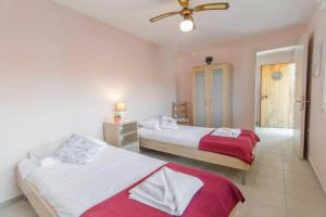 - une chambre avec 2 lits et un ventilateur de plafond dans l'établissement Amalia Sea View house, à Vathi