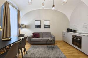 eine Küche und ein Wohnzimmer mit einem Sofa und einem Tisch in der Unterkunft Vienne City Apartment Crown 6 in Wien