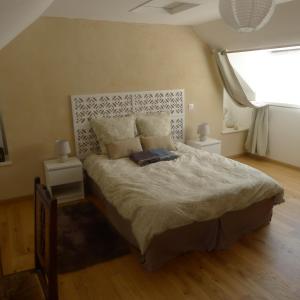 アンボンにあるTy Bétahon - 200m de la plageの大きなベッドと2つのナイトスタンドを備えた寝室