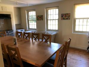 a dining room with a large wooden table and chairs at The Wing at Brook Hall in Tadcaster