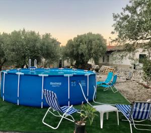 einen Pool im Garten mit Stühlen und einem Tisch in der Unterkunft Villa Luce in Modica