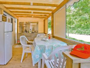 a dining room with a table and a refrigerator at Portofelice Camping Village in Eraclea Mare