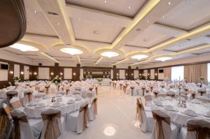 duża sala bankietowa z białymi stołami i krzesłami w obiekcie Hotel Majdan w Belgradzie
