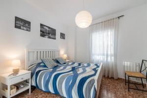 セビリアにあるAnna - Trianaの白と青のストライプのベッドが備わる白いベッドルーム1室