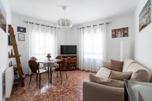 ein Wohnzimmer mit Sofa und Tisch in der Unterkunft Anna Triana Boutique Apartament in Sevilla