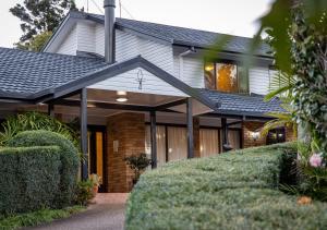 a brick house with a black roof at Mountain Sanctuary B&B in Mount Tamborine