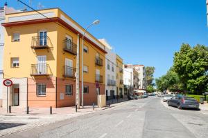 ein gelbes Gebäude am Straßenrand in der Unterkunft Anna Triana Boutique Apartament in Sevilla