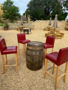 a group of chairs and a barrel with tables and umbrellas at Horse & Hound Inn in Broadway