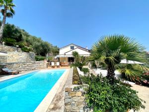 a swimming pool with a palm tree next to a house at ABCdecor Italia in Imperia