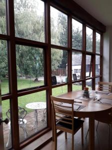 a dining room with large windows and a table and chairs at Brook Barn B&B in Hale