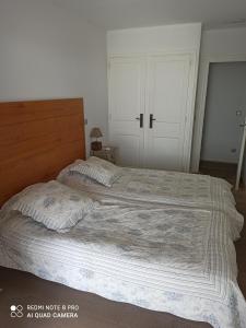 マルセイヤンにあるPort rive gauche Oyatのベッドルーム1室(大型ベッド1台、木製ヘッドボード付)