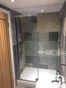 a glass shower in a bathroom with a sink at Worship Farm Accommodation in Redhill