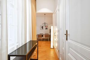 um corredor com uma mesa de vidro e uma sala de jantar em Herzfeld Arthaus Vienna Premium Apartments em Viena