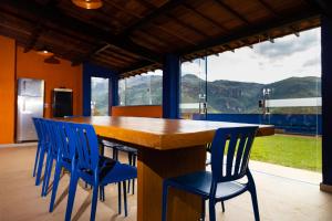 uma cozinha com uma grande mesa de madeira e cadeiras azuis em Estâncias da Serra dos Alves em Itabira