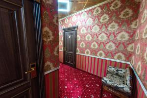 un couloir avec des murs rouges et un tapis rouge dans l'établissement Ефремовъ, à Armavir