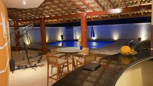 a room with a pool and a table and chairs at Casa de Campo Alto Padrao in Piracaia