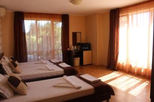 a hotel room with two beds and a large window at Respekt Guest House in Sunny Beach