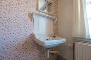 亨能史特蘭德的住宿－Det Gamle Badehotel - Klitgaarden，浴室设有水槽和墙上的镜子