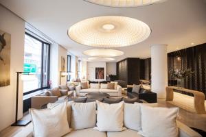 a living room with a large couch and a large chandelier at Quentin XL Potsdamer Platz in Berlin