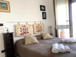 een slaapkamer met een groot bed en handdoeken bij Casa Confalonieri fronte mare con vista mozzafiato in San Benedetto del Tronto