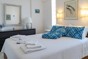 a bedroom with a bed with towels on it at Yoga Euphoria seaside apartment in Artemida