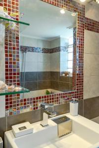 a bathroom with a sink and a mirror at Yoga Euphoria seaside apartment in Artemida +43 photos
