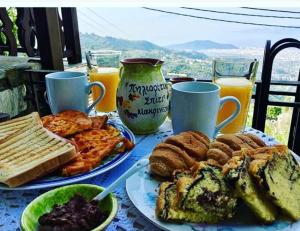 a table with two plates of breakfast foods and drinks at Pilioritiko Spiti in Makrinítsa