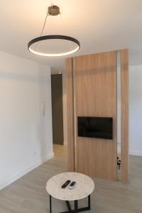 een woonkamer met een tafel en een flatscreen-tv bij Villa Malo More in Trogir