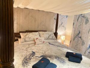 ein Bett mit einem Baldachin mit zwei Kissen darauf in der Unterkunft Lake District romantic get away in 1 acre gardens off M6 in Penrith