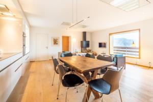 a dining room and living room with a table and chairs at LAAX Homes - Casa Fau in Laax