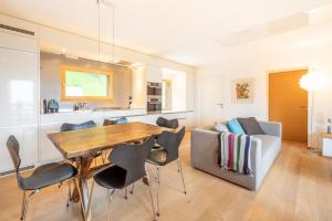 a kitchen and dining room with a wooden table and chairs at LAAX Homes - Casa Fau in Laax
