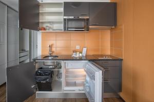 a kitchen with a stove top oven and a microwave at Hotel Residence Loren in Uster