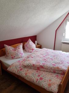 a bedroom with a large bed with pink sheets and pillows at Ferienwohnung Willkommen in Bad Schandau