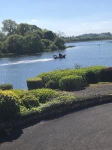 um barco num rio com uma pessoa nele em Ardhowen Bay lakefront holiday accommodation em Enniskillen