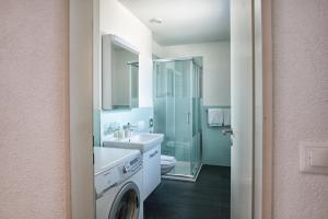 a bathroom with a sink, toilet, and shower at Hotel Residence Loren in Uster