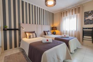 um quarto de hotel com duas camas e uma janela em Casa da Praia na Zambujeira do Mar