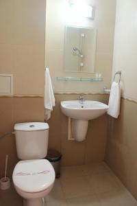 a small bathroom with a toilet and a sink at Respekt Guest House in Sunny Beach +53 photos