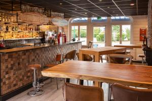 un restaurante con mesas y sillas y un bar en Cocoon inn en Cucq