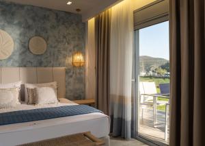 a bedroom with a bed and a balcony at Notia Luxury Living in Porto Koufo